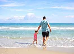 Father and child walking on beach