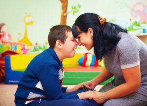 Mother holding hands with her special needs son