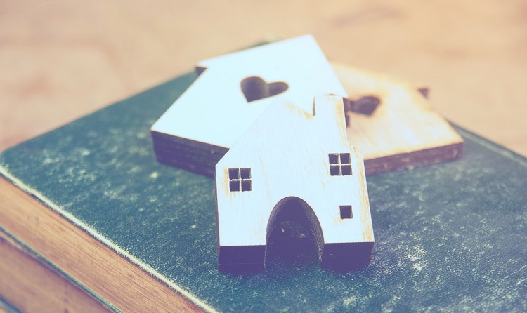 Wooden cut out in the shape of houses on top of an old book