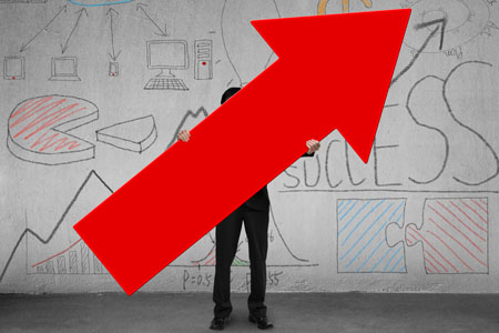 Business man holding up large red arrow