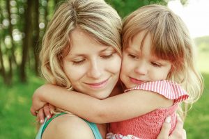 Mother holding and hugging young daughter