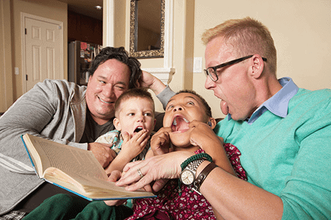 Two children with their fathers being silly.