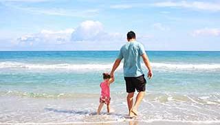 Father and child walking on beach