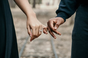 Man and woman with ring holding hands