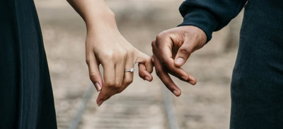 Man and woman with ring holding hands