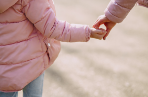 child and mother holding hands