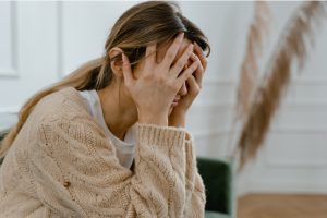 woman with hands covering her face