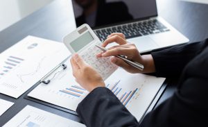 Woman at desk using calculator 