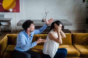 Man yelling at woman on couch