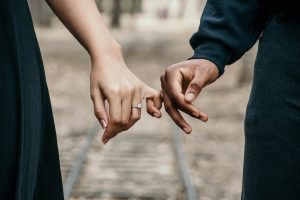 Hands with wedding ring and fingers interlocked