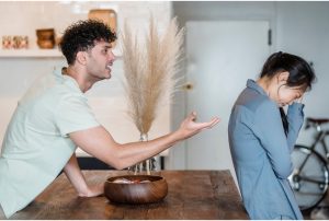 Man motioning with hand toward woman and woman crying.