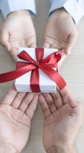 Child and adult hands holding gift