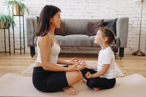 Woman and girl sitting on floor facing each other