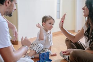 Child and parents sitting on floor playing a game