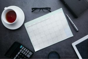 Cup of coffee and calendar on a desk