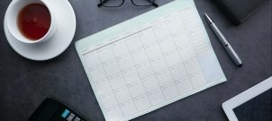 Cup of coffee and calendar on a desk