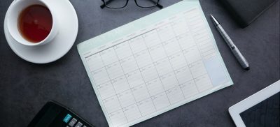 Cup of coffee and calendar on a desk