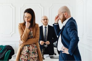 Woman and man standing in front of desk with man behind desk