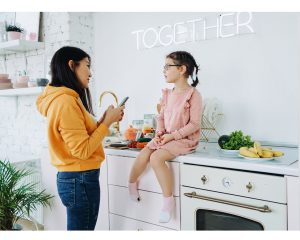 Child sitting on counter with woman standing in front