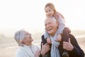 Grandmother and Grandfather smiling with child on his shoulders