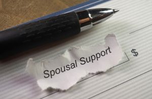 Pen and check with words "Spousal Support" written on small piece of paper