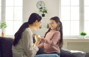 Woman and child holding hands and looking at one another