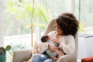 Woman sitting in a chair holding a newborn baby