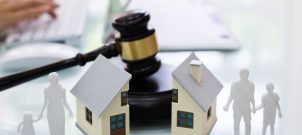 Gavel with house split in half and cutouts of family on either side