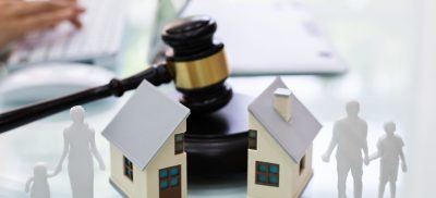 Gavel with house split in half and cutouts of family on either side