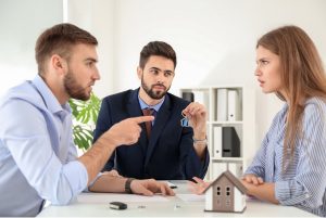 Man and woman arguing at a table with attorney