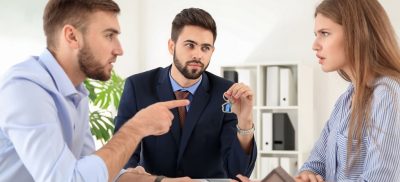 Man and woman arguing at a table with attorney
