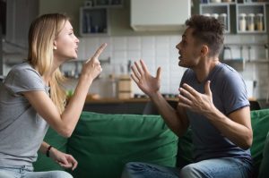 Man and Woman arguing on a green couch