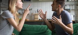 Man and Woman arguing on a green couch