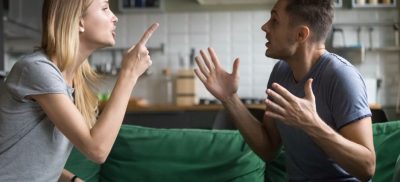 Man and Woman arguing on a green couch