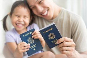 Adult and child smiling holding passports