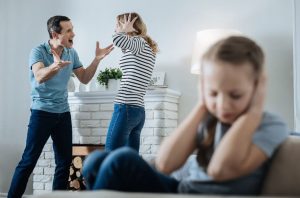 Parents arguing and a child covering her ears