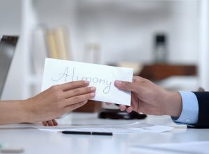 Alimony envelope being handed from one person to another