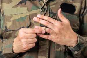 Man in military uniform removing ring