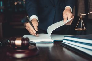 Desk with a gavel and a man writing in a book